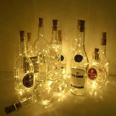 several bottles with lights on them sitting next to each other