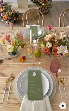 the table is set with flowers and plates