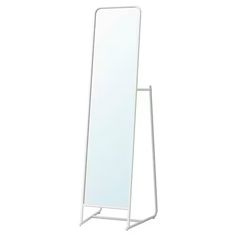 a white standing mirror on top of a metal stand with an empty shelf below it