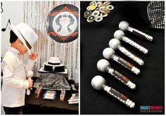 a boy wearing a white hat standing next to a table with silver and black decorations