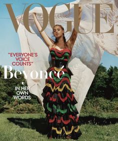 a woman in a colorful dress on the cover of a magazine, with her arms outstretched