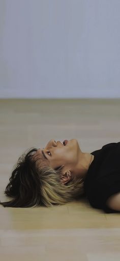 a woman laying on the floor with her eyes closed