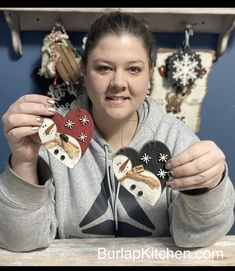 a woman holding two heart shaped ornaments in front of her face