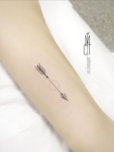 a small arrow tattoo on the arm