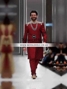 a man in a red outfit walking down the runway