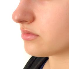 a close up of a woman's face with her nose piercings on it