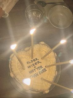 a cake with candles on it that says older, wise, hotter, than ever