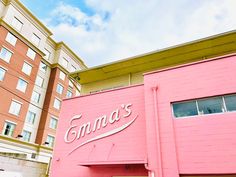 a pink building with the word cinnamon's written on it in front of some buildings