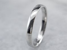 Simple and subtle, this platinum band features a low dome on top and a beautiful, soft polish. The profile and finish are completely un-decorated giving this piece a nice profile for a man or a woman. This band has a perfect polish and is ready to wear! Metal: Platinum Width of Band: 2.4 mm Height off Finger: 1.1 mm Ring Size: 6 Marks: "PLAT950FG" Stamped on the inside band Timeless Wedding Bands With Polished Finish, Luxury White Gold Thick Band, Timeless Formal Wedding Jewelry With Smooth Bezel, Wedding Ring With Smooth Bezel And Thick Band, Timeless Formal Bands With Smooth Bezel, Elegant Wedding Band With Smooth Finish, Classic Rings With Shiny Round Band, Classic Rings With Shiny Finish And Round Band, Polished Round Band For Wedding And Anniversary