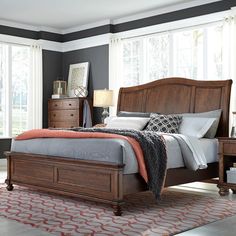 a bedroom with a bed, dressers and two lamps on the side of the room