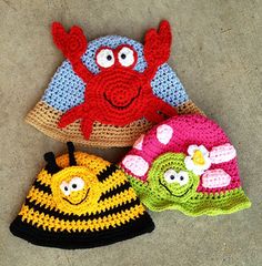 three hats with different designs on them, one has a bee and the other has a flower