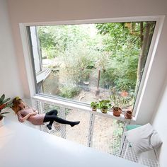 a woman is sitting on the window sill