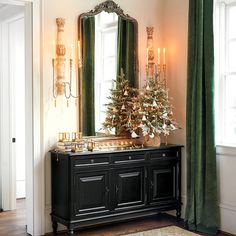 a christmas tree is sitting on top of a black cabinet in the corner of a room