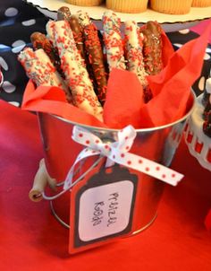 some cupcakes are in a tin on a table with red and black decorations