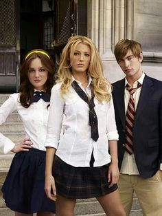 three young people in school uniforms posing for the camera