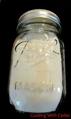 a mason jar filled with white flour on top of a table