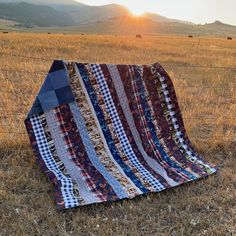 a quilt is laying on the ground in a field