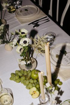 the table is set with flowers and fruit