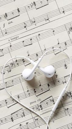 an earbud laying on top of sheet music