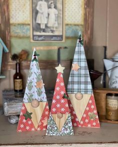 three wooden christmas trees sitting on top of a table