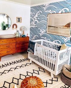 a baby's room with a crib, dresser and mirror on the wall