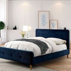 a blue bed with white sheets and pillows