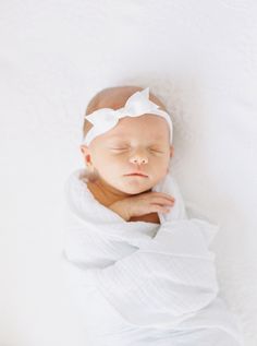 a newborn baby wrapped in a white blanket