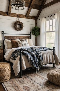 a bedroom with white walls and wood floors, a bed frame is made up in plaid blankets