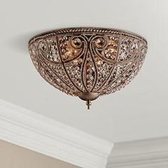 a fancy light fixture hanging from the ceiling in a room with white walls and trimmings