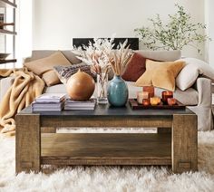 a living room filled with lots of furniture and decor on top of a white rug