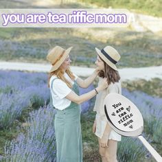 two women standing next to each other in front of lavender flowers with the words, you are tea afiic mom