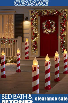 lighted candles in front of a house decorated for christmas