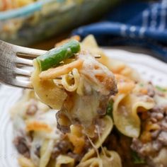 a fork full of pasta with meat and vegetables