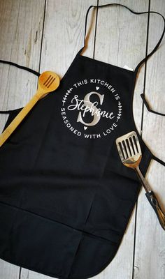 a black apron with a spatula and wooden utensils