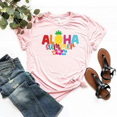 "Aloha Summer Hibiscus Shirt, Aloha Summer T-Shirt, Hawaii Vacation Shirt, Summer Trip Shirt, Aloha Tee, Cute Aloha Shirt, Tropical Shirt ☀️☀️☀️☀️☀️ Everything in our shop is hand crafted and made to order. If you want different color or size contact me! If you would like something custom made to fit your personal style please message me and I will do everything to get you that something special. ---How To Order--- ⭐️Please, check and review all photos ⭐️Choose your t-shirt size and color ⭐️Ente Multicolor Hawaiian T-shirt For Summer, Pink Hawaiian Short Sleeve T-shirt, Tropical Print Short Sleeve T-shirt, Cotton T-shirt With Tropical Print, Multicolor Crew Neck Shirt For Vacation, Multicolor Hawaiian T-shirt For Beach Season, Pink Hawaiian Cotton Top, Casual Pink Hawaiian Shirt With Hibiscus Print, Cotton Tropical Print T-shirt