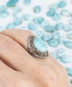 "Beautifully designed and crafted, this Natural Larimar Gemstone oval ring is a statement piece. The ring face is made from sterling silver and features a high polished finish that reflects light beautifully. It has beautifully two daisy figures on both sides. It comes in sizes 5 to 12 sizes and has faceted, cabochon oval-cut gemstones on its top add more beauty to the piece. The high-quality sterling silver used in this design ensures durability, while keeping the price affordable.           A beautiful sterling silver blue - turquoise stone cocktail ring is the perfect gift for Valentine`s day, mother`s day, Thanksgiving, New Year and Christmas.  The 0.97\" / 24.70 mm X 0.65\" / 16.50 mm ring face will be fit to your finger elegantly. This unique ring comes packaged in a luxurious gift b Oval Stone Ring Design, Ring Design Silver, Stone Ring Design, Oval Stone Ring, The Ring Face, Long Ring, Silver Polish, Statement Ring Silver, Oval Ring