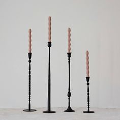 four candles are lined up in the shape of three poles with one candle sticking out of it