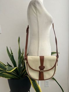 Super cute, cream colored pebbled leather with brown trim, cross-body handbag with adjustable strap. Bag is lined in plaid, has one inner zippered pocket, one open pocket in the front, and a snap closure in the front. In overall great vintage condition with no major flaws, although there are a couple spots on the back and side with a bit of blue transference, only noticeable when closely inspecting. Logo, placket and hardware all say Guess. Dimensions Height 9in/23cm Across 11in/28cm (at the top) Width 3.5in/9cm Strap 51in/129.5cm (longest) *Please keep in mind that unless otherwise noted, all items in my shop are used or previously owned, normal wear and tear is expected, flaws that are noted are range from major to minor, things like a missing stitch here or there my not be included. *Pl Retro Crossbody Satchel For Errands, Cream Leather Bag For Fall, Cream Shoulder Bag For Fall, Classic Cream Bags With Leather Lining, Classic Satchel With Leather Trim For Errands, Cream Shoulder Bag With Leather Trim, Cream Shoulder Bag With Leather Lining For Travel, Travel Cream Shoulder Bag With Leather Lining, White Shoulder Bag With Detachable Strap For Fall