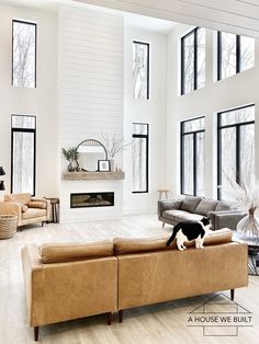 a living room filled with lots of furniture next to large windows on top of a hard wood floor