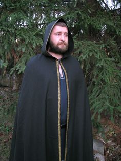 "Shop now Long medieval hooded cloak for men! Medieval hooded cloak in dark green wool with golden trim embellishment. Awesome Medieval prince' cape, viking cloak, elven hooded cape. Just perfect for LARP events, viking festivals, renfaire events etc. See more hooded cloaks here https://www.etsy.com/shop/EthnicandMedieval?ref=seller-platform-mcnav&section_id=35034993 The length (top shoulder to hem) - 59\" (150 cm).  The fabric is a pure 100% wool, really stunning colour. It has a velvet shine t Hooded Medieval Cape For Larp, Elven Style Cape For Medieval Festivals And Costume Events, Elven Style Cape For Medieval Festivals, Elven Outerwear For Medieval Festivals, Elven Cape For Medieval Festivals And Costume Events, Elven Cape For Medieval Festivals, Medieval Hooded Cape For Fantasy Events, Fantasy Hooded Cape For Larp, Elvish Hooded Cape For Larp