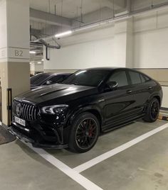 two black cars parked in a parking garage