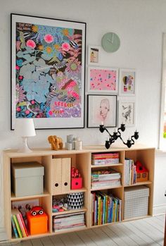 a book shelf with books and pictures on the wall