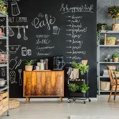 a chalkboard wall in the corner of a room with plants and other things on it