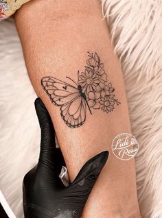 a woman's leg with a butterfly and flowers tattoo on her left calf sleeve