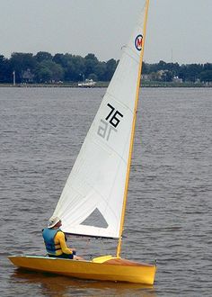 a man riding on the back of a yellow sailboat in a body of water