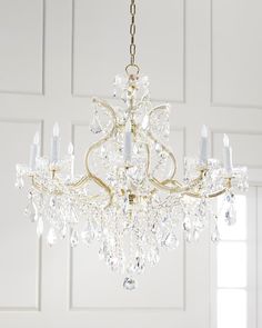 a chandelier hanging from the ceiling in a room with white walls and doors