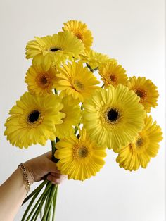 a person holding a bouquet of yellow flowers