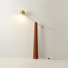 a lamp that is on top of a white table next to a wall with a light