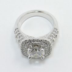 a white gold engagement ring with an oval cut diamond surrounded by pave set diamonds