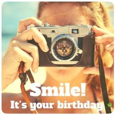 a woman holding up a camera with the words smile it's your birthday